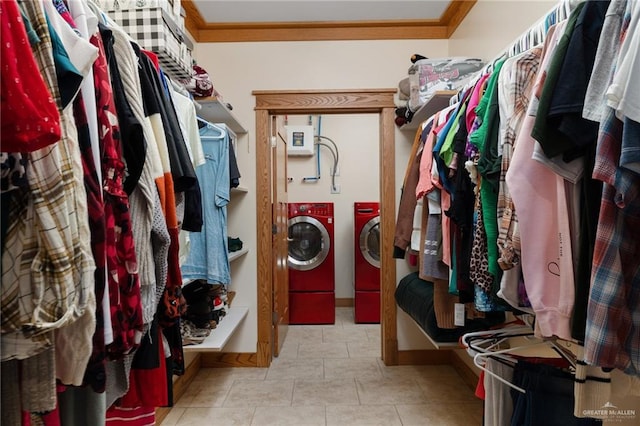 spacious closet with light tile patterned floors and washing machine and clothes dryer