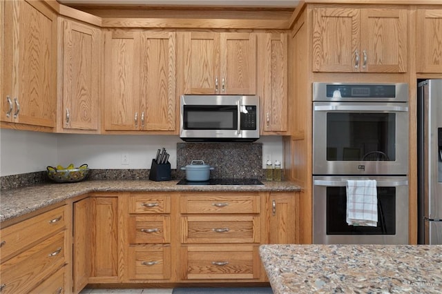 kitchen featuring light stone countertops, appliances with stainless steel finishes, and light brown cabinetry