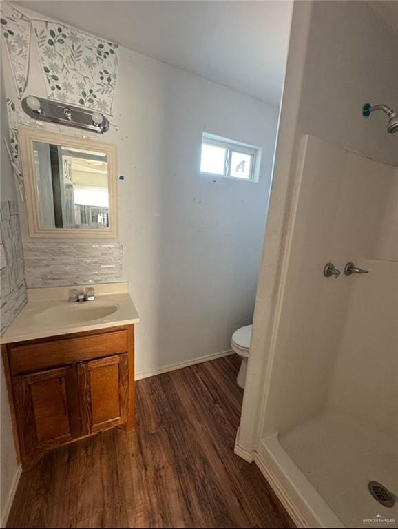 bathroom featuring walk in shower, vanity, toilet, and hardwood / wood-style floors