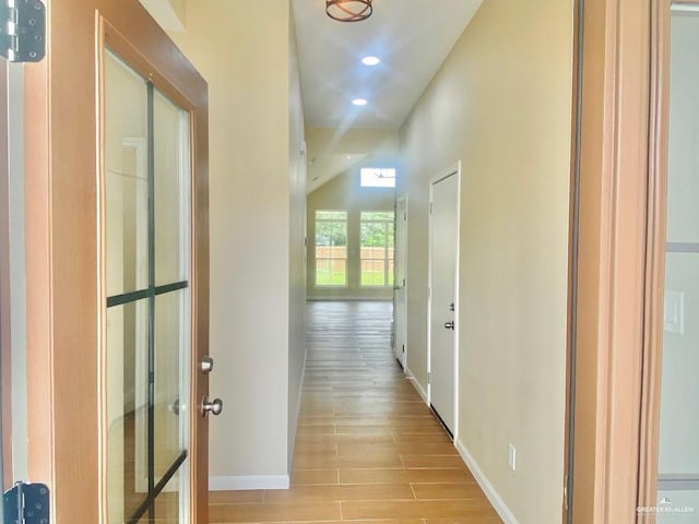 hall featuring recessed lighting, baseboards, and light wood finished floors