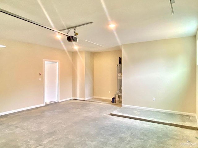 garage featuring baseboards, a garage door opener, and water heater