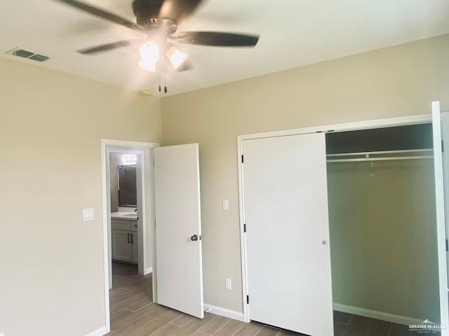 unfurnished bedroom with a ceiling fan, baseboards, wood finished floors, visible vents, and a closet