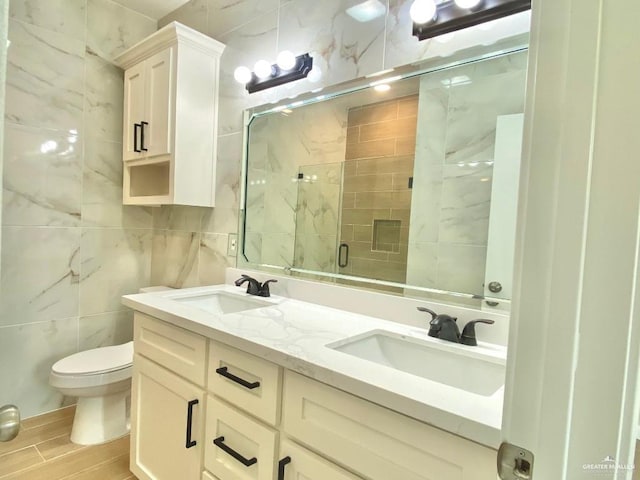 full bathroom featuring wood finished floors, a sink, a stall shower, and tile walls