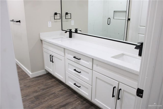 bathroom featuring vanity, wood-type flooring, and a shower with shower door