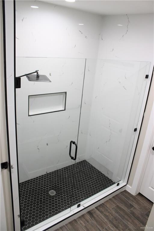 bathroom featuring hardwood / wood-style floors and a shower with door