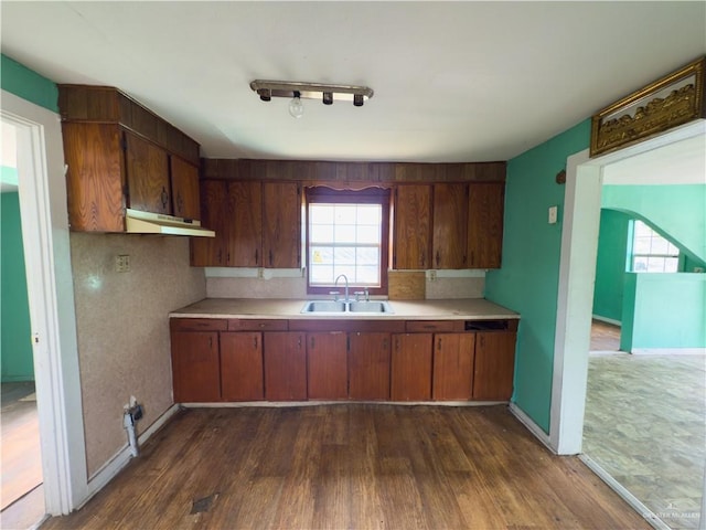 210 N Palmas St, Weslaco, TX 78596 - kitchen featuring a sink, light countertops, dark wood finished floors, under cabinet range hood, and baseboards