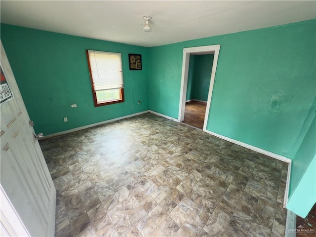 210 N Palmas St, Weslaco, TX 78596 - empty room with baseboards and stone finish flooring