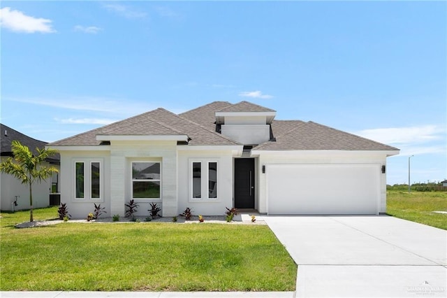 prairie-style house featuring a garage and a front lawn