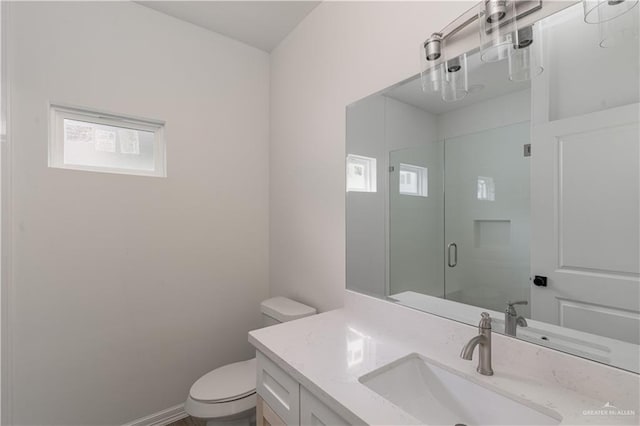 bathroom with vanity, a shower stall, and toilet