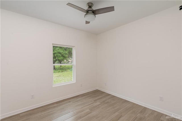 spare room featuring baseboards, light wood-style flooring, and ceiling fan