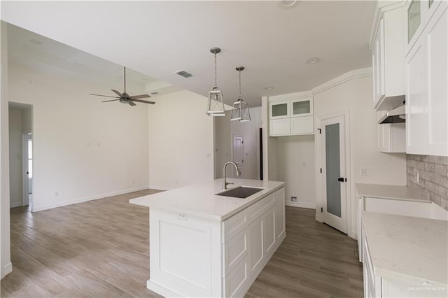 kitchen with visible vents, a sink, white cabinetry, and a ceiling fan