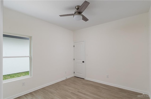 spare room featuring baseboards, a ceiling fan, and light wood-style flooring