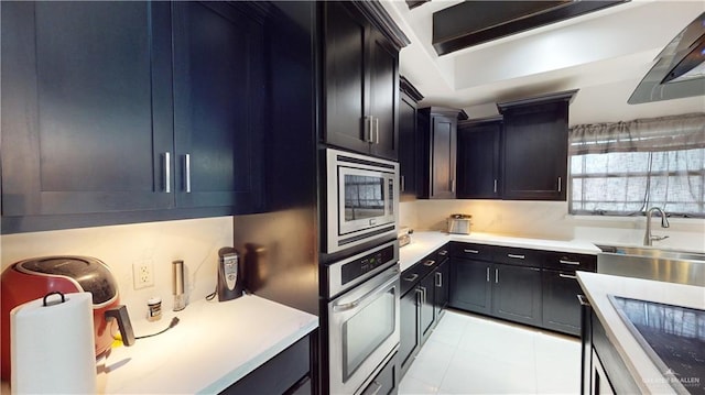 5403 Mauritius Ln, Edinburg, TX 78542 - kitchen with light tile patterned floors, a sink, wall chimney range hood, light countertops, and appliances with stainless steel finishes