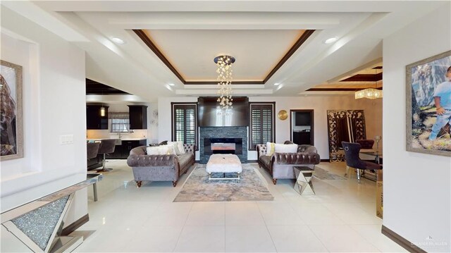 5403 Mauritius Ln, Edinburg, TX 78542 - tiled living area with an inviting chandelier, a raised ceiling, crown molding, and a glass covered fireplace
