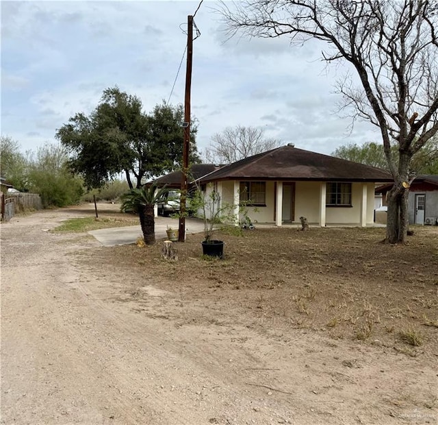 view of front of home featuring a carport and dirt driveway