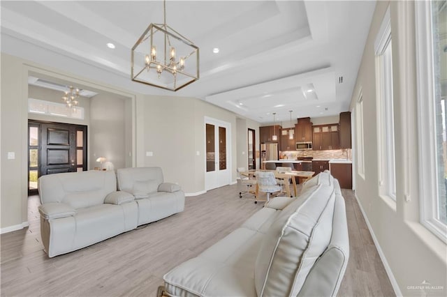 4001 Santa Erica St, Mission, TX 78572 - living room with a tray ceiling, a chandelier, baseboards, and light wood-style flooring