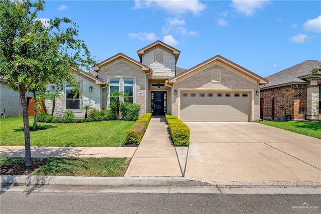 4001 Santa Erica St, Mission, TX 78572 - view of front of property featuring a garage, a front lawn, concrete driveway, stone siding, and brick siding