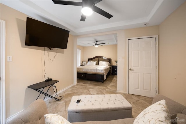 tiled bedroom featuring a raised ceiling and ceiling fan