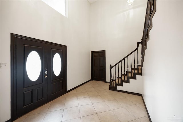 tiled entryway featuring a towering ceiling