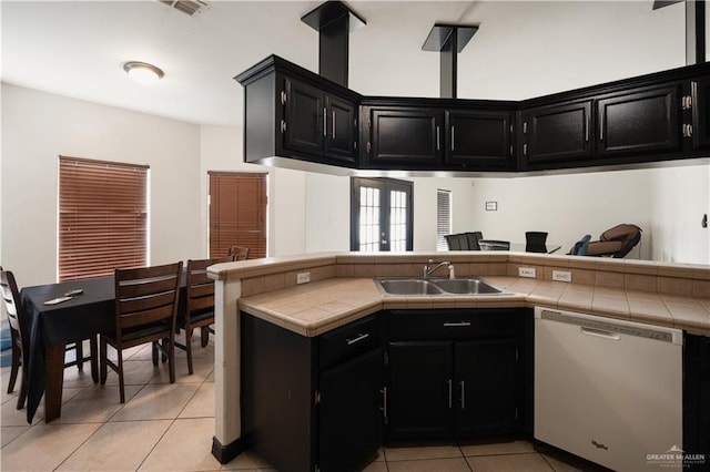 kitchen featuring tile countertops, dishwasher, light tile patterned flooring, and sink