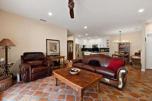 living room featuring light tile patterned floors and ceiling fan with notable chandelier