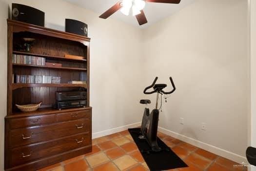 workout area with light tile patterned floors and ceiling fan