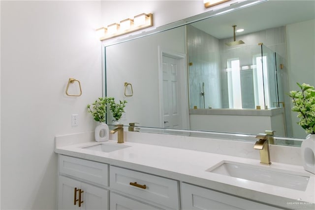 bathroom with double vanity, a shower stall, and a sink