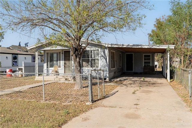 view of front of property with a carport, concrete driveway, and a fenced front yard