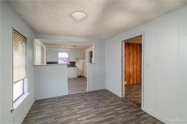 empty room with dark wood-style floors and a textured ceiling