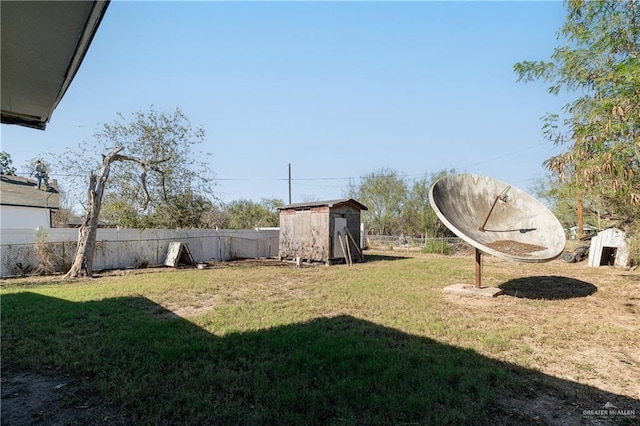 view of yard with a shed, fence, and an outdoor structure