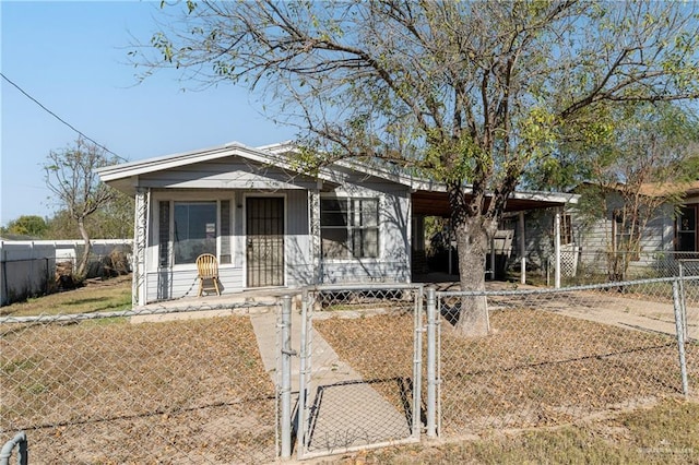 view of front of house with a fenced front yard, covered porch, driveway, and a gate