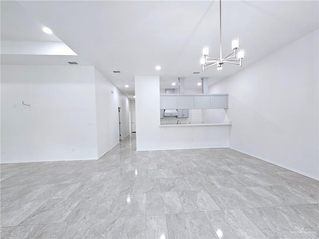 unfurnished living room with a notable chandelier