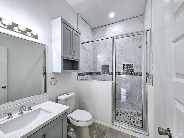 bathroom featuring vanity, a shower with door, and toilet