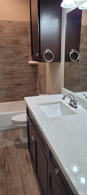 bathroom with hardwood / wood-style floors, vanity, and toilet