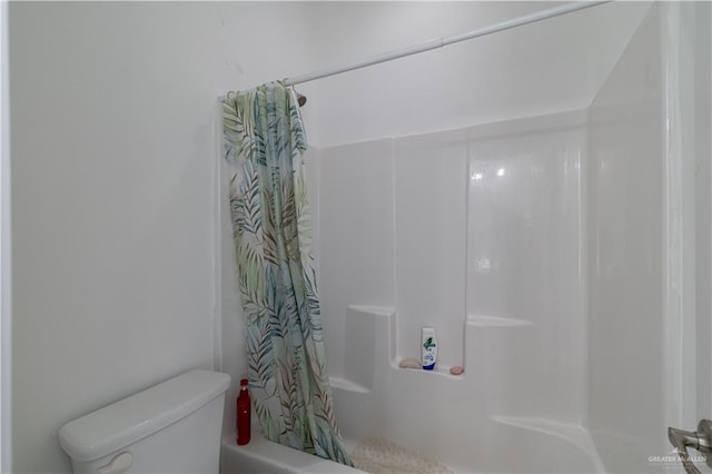 bathroom with shower / bath combination with curtain and toilet