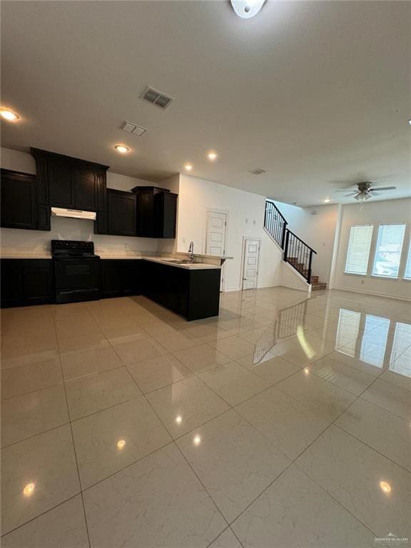 kitchen featuring kitchen peninsula, black stove, light tile patterned flooring, and sink