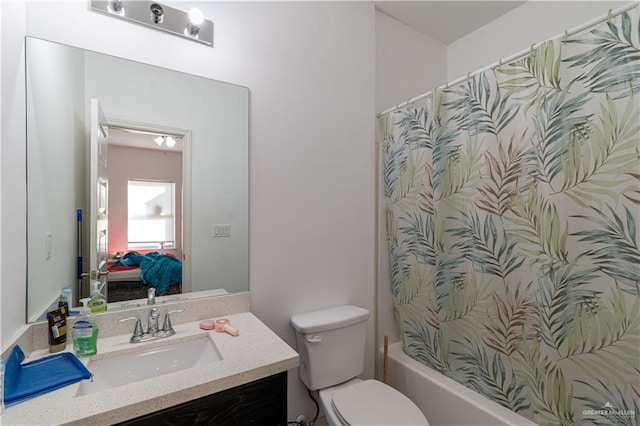 full bathroom with vanity, shower / tub combo, and toilet