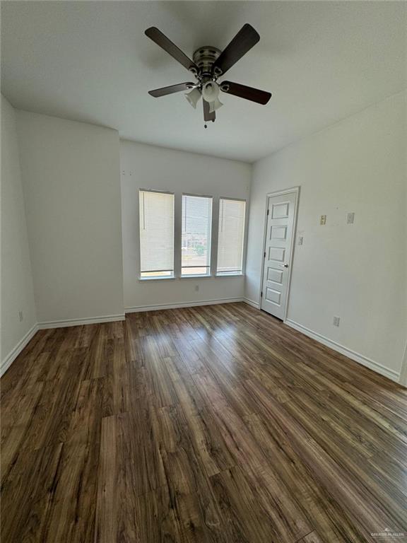 spare room with ceiling fan and dark hardwood / wood-style floors