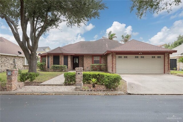 409 Kiwi Ave, Mcallen, TX 78504 - ranch-style house featuring an attached garage, concrete driveway, and brick siding