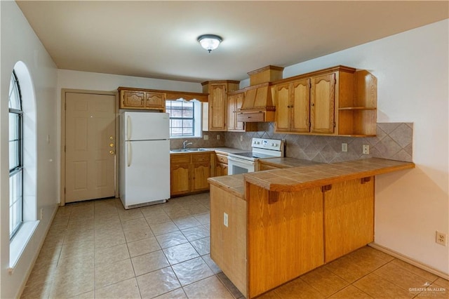 kitchen featuring sink, backsplash, kitchen peninsula, tile countertops, and white appliances