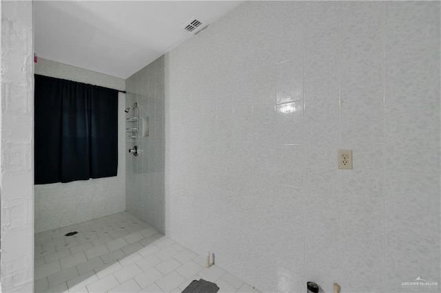 bathroom featuring a tile shower and tile patterned flooring