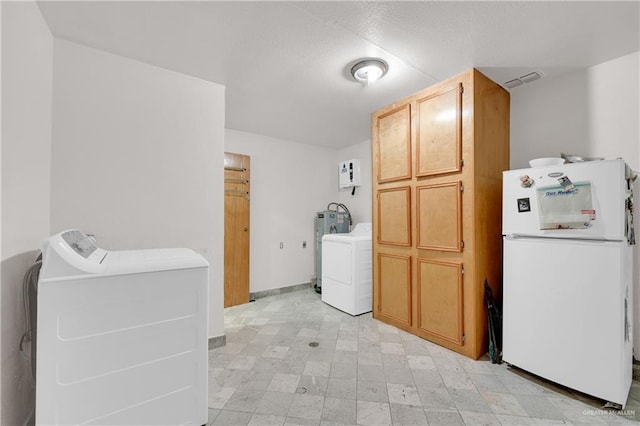 washroom with washer and dryer, cabinets, and electric water heater