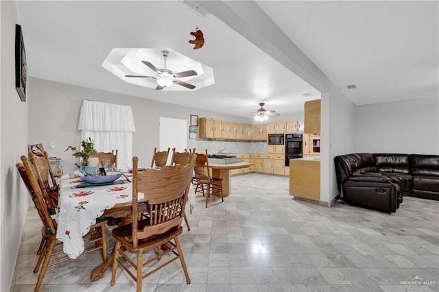 dining area with ceiling fan and sink