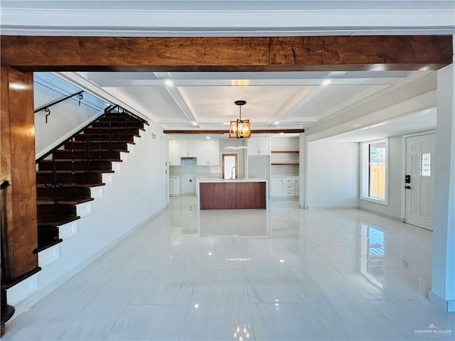 interior space featuring sink, white cabinetry, backsplash, beam ceiling, and decorative light fixtures