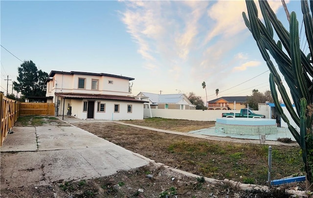 back of property featuring a fenced in pool