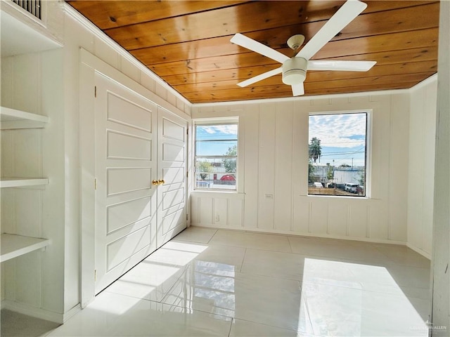 unfurnished room with light tile patterned floors, wooden ceiling, and ceiling fan