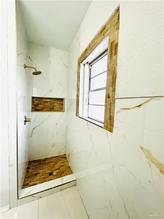 bathroom featuring a tile shower