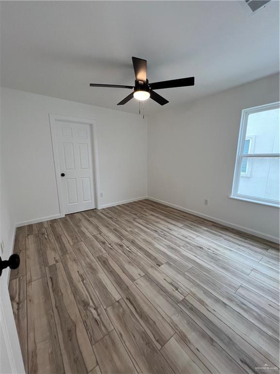 empty room with baseboards and wood finished floors