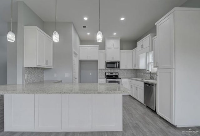 3708 Climax Dr, Edinburg, TX 78542 - kitchen featuring appliances with stainless steel finishes, a peninsula, light stone countertops, tasteful backsplash, and recessed lighting