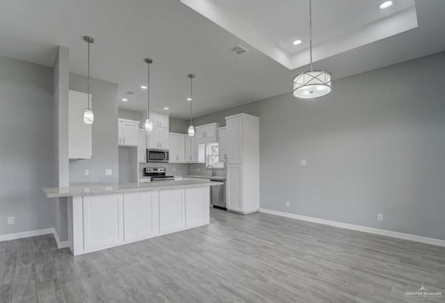 3708 Climax Dr, Edinburg, TX 78542 - kitchen featuring appliances with stainless steel finishes, a peninsula, white cabinetry, light wood-style flooring, and recessed lighting